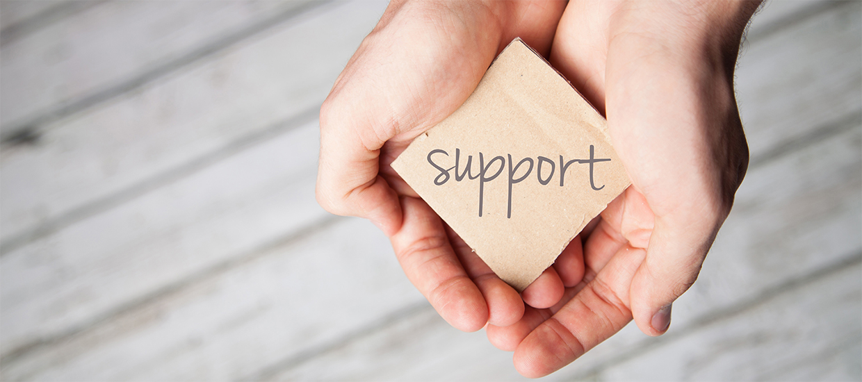 Image of hands holding a sign that reads "Support"